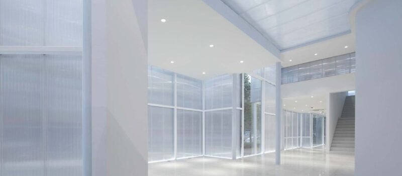 A domer skylight is featured in the image, its sleek design and clear polycarbonate material allow natural light to flood the room. It has a modern and minimalistic look with a white aluminum frame, which seamlessly blends with any architectural style. The skylight appears to be installed providing ample natural light to the interior space.